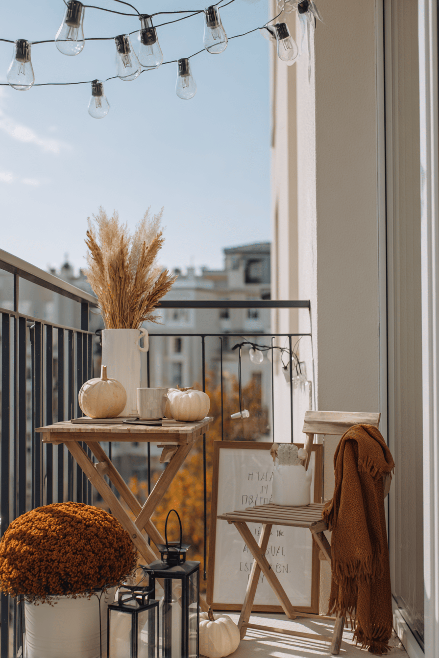 Abendlicher Balkon mit warmen Lichterketten und Laternen zwischen herbstlichen Pflanzen.