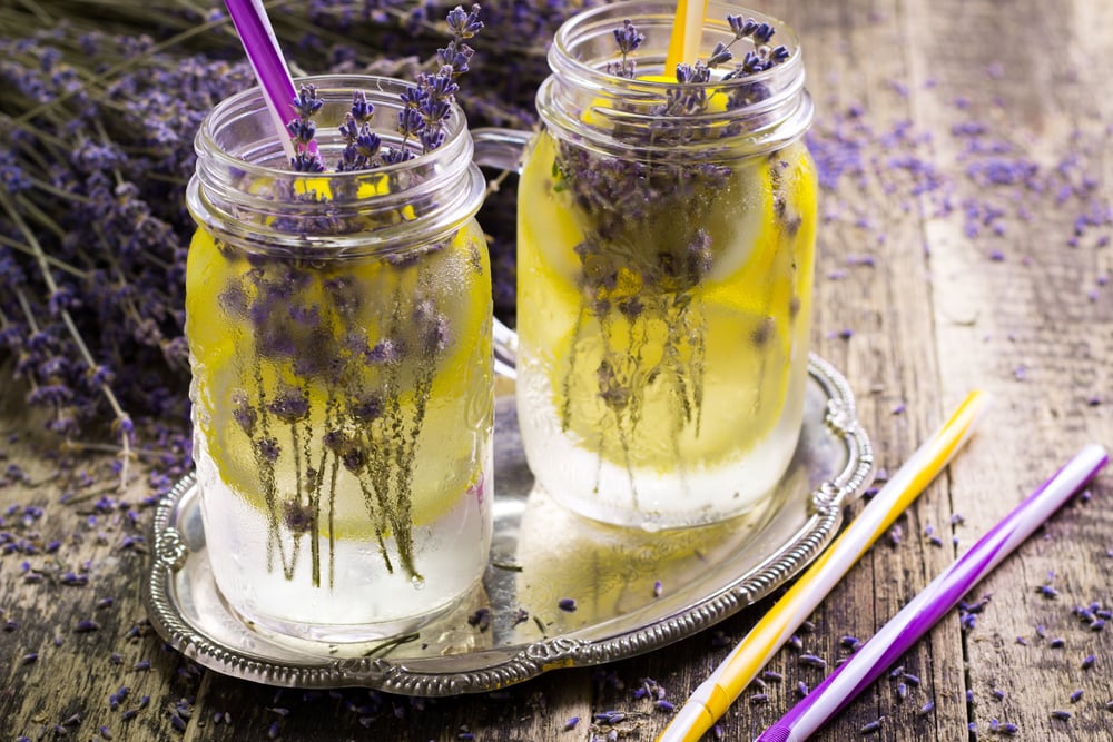 Glas mit hellvioletter Lavendel-Limonade und Eiswürfeln