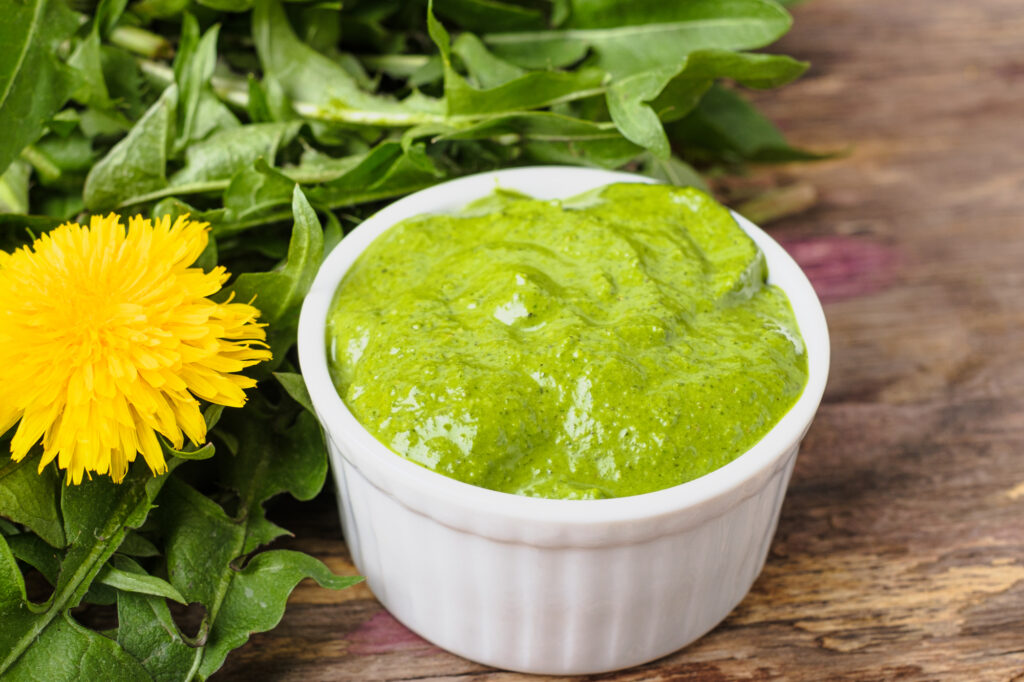 Löwenzahnblätter und Pesto in Schale