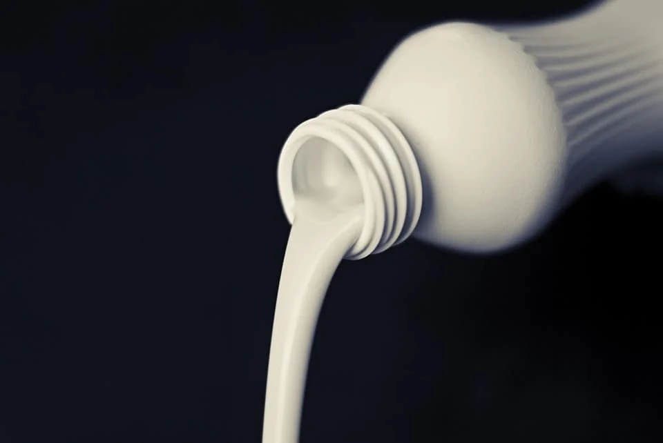 Milch wird aus einer Flasche gegossen