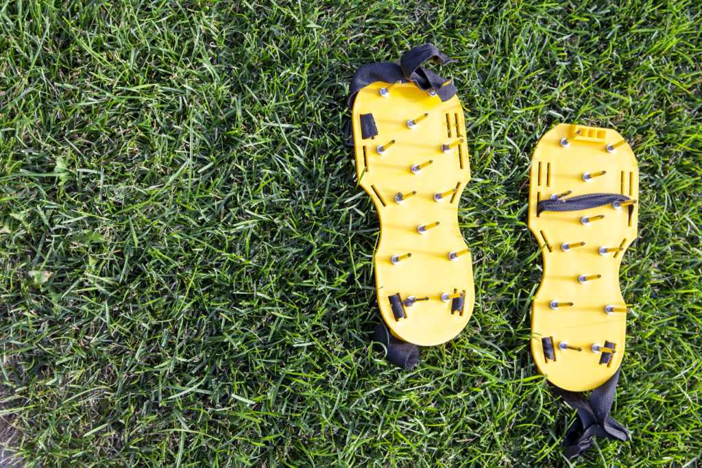 Gelbe Rasenlüfterschuhe auf grünen Rasen