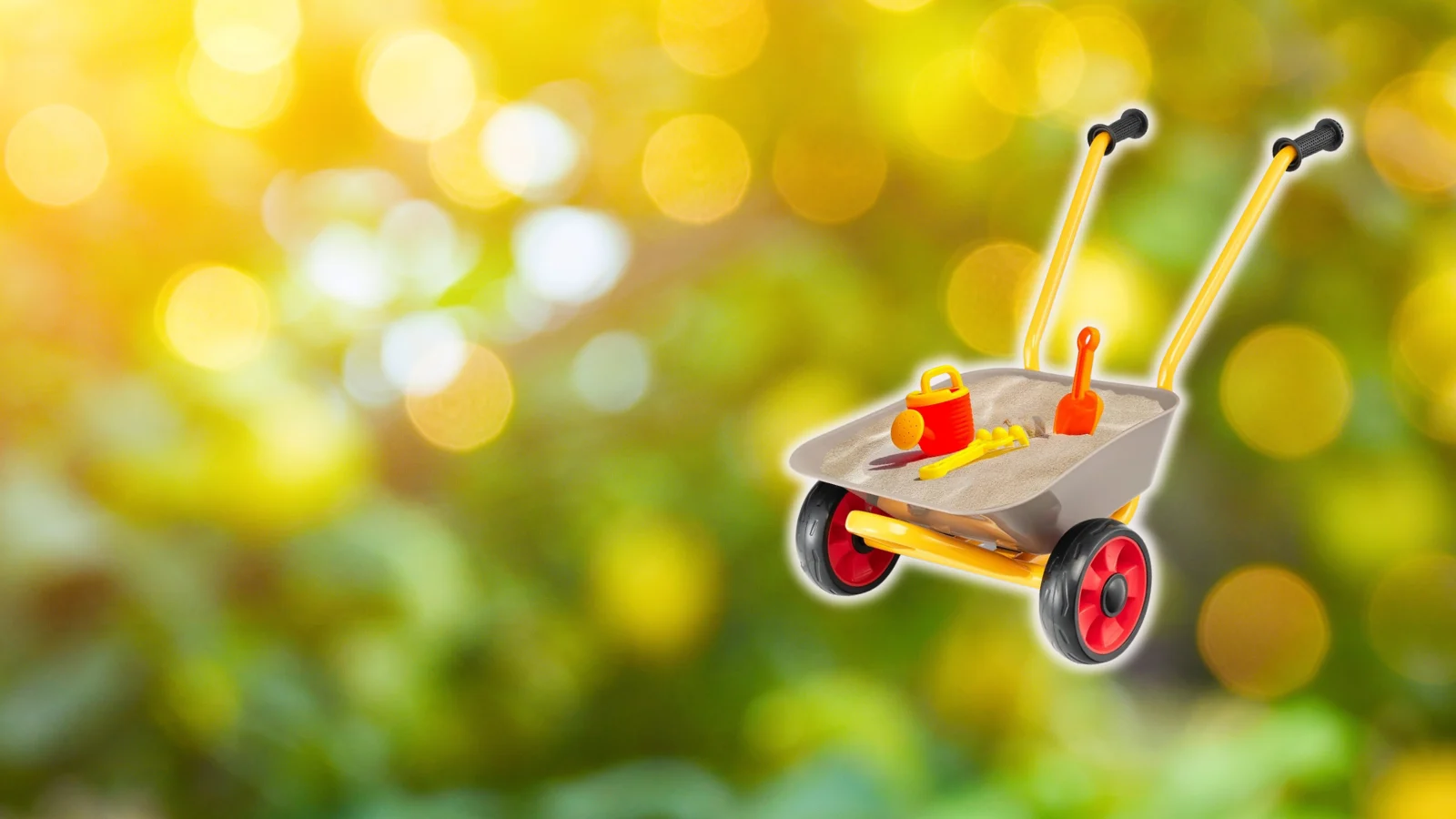 Kinder-Schubkarre mit Spielzeugsand und -werkzeug.